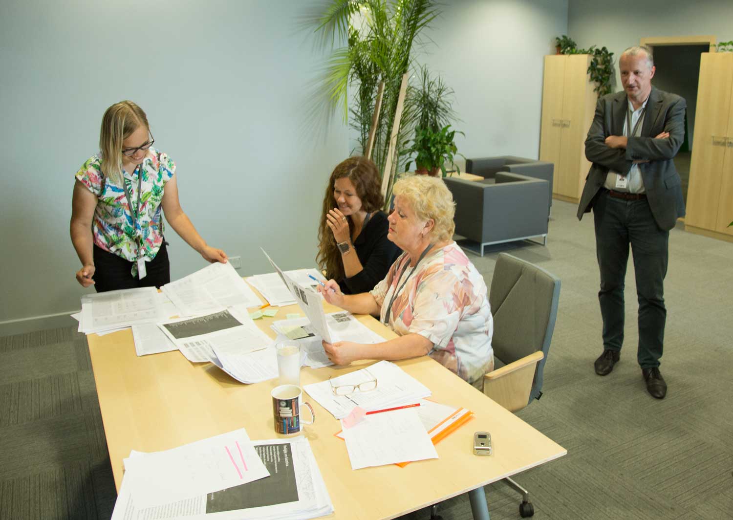 Astrīda Iltnere (centrā) kopā ar redaktorēm Santu Jērāni (no kreisās) un Ilzi Fogeli, un galveno redaktoru Valteru Ščerbinski, strādājot pie Nacionālās enciklopēdijas drukātā sējuma "Latvija". Rīga, 2018. gads.