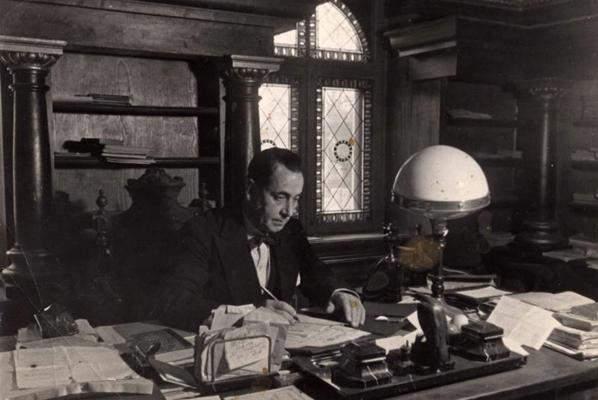 Eduards Smiļģis savā mājā Dārtas ielā 37/39 (tagad E. Smiļģa iela) kabinetā pie galda. Rīga, 1937. gads.