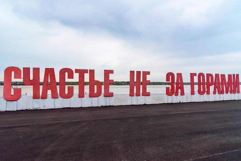 Uzraksts krievu valodā Kamas upes krastmalā “Laime nav aiz kalniem”. Perma, Krievija, 19.09.2017.
