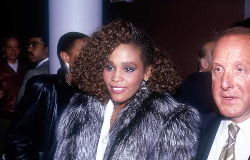 Vitnija Hjūstone un Klaivs Deiviss, atzīmējot dziedātājas debijas albumu "Whitney Houston". Ņujorka, 1985. gads.
