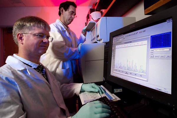 CDC mikrobiologi Glens Morloks (Glenn Morlock) un Mičs Jakruss (Mitch Yakrus) darbā ar DNS sekvencēšanas iekārtu. 2007. gads.