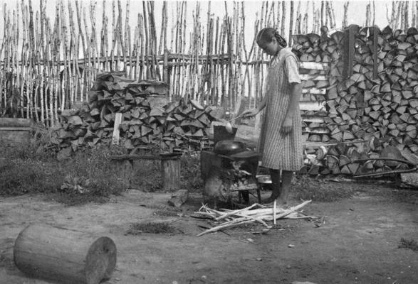 Deportētā Aina Krēmere pagalmā gatavo ēdienu. Boļšije Kļuči, 1954. gads.