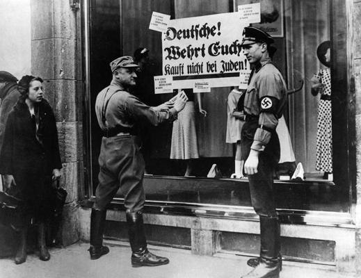 Pie ebreju veikala tiek piesiprināti pretebreju kampaņas lozungi. Berlīne, 1933. gads.