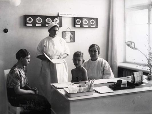 Bērna apskate Veselības kopšanas parauga punktā Latvijas Sarkanā Krusta Žēlsirdīgo māsu skolā. Rīga, 1937.–1939. gads.
