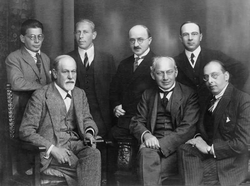 Priekšplānā no kreisās: Zigmunds Freids, Šāndors Ferenci (Sándor Ferenczi), Hanss Zahss, aizmugurē no kreisās: Oto Ranks, Karls Abrahams (Karl Abraham), Makss Eitingons (Max Eitingon) un Ernsts Džonss (Ernest Jones). 1922. gads.