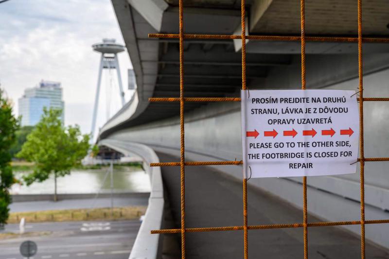 Norāde slovāku un angļu valodā vēsta "Lūdzam pāriet otrajā pusē, gājēju celiņš ir slēgts remontam". Bratislava, Slovākija, 09.07.2019.