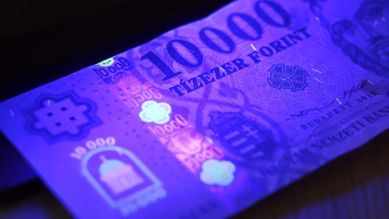 Ungārijas forintu banknotes pretviltošanas zīmju luminiscence ultravioletā starojuma iedarbības rezultātā. Varšava, Polija, 2021. gads.