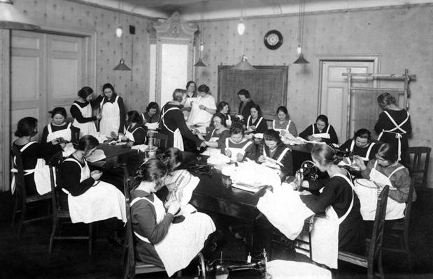Kaucmindes Mājturības skolas audzēkņi izšūšanas nodarbībā. Saulaine, 1930. gads.