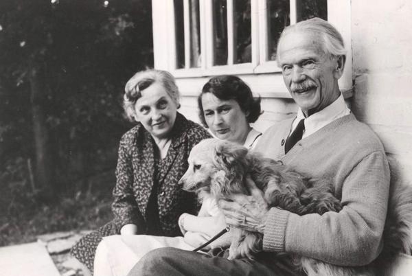 Jānis Jaunsudrabiņš ar meitu Liliju Jaunsudrabiņu (pirmā no kreisās) un viešņu pie mājas. Klēpī sunītis Zuzīte. Vācija, 1961. gads.