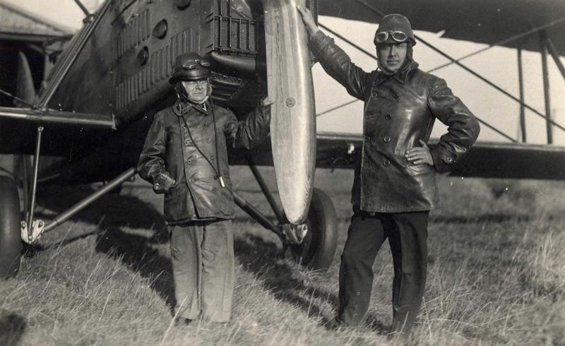 No kreisās: Edvarts Virza un Eduards Smiļģis lidotāju tērpos pie lidmašīnas. 20. gs. 30. gadi.