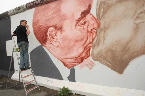 Krievu mākslinieks Dmitrijs Vrubels (Дмитрий Владимирович Врубель) pārkrāso savu vēsturisko sienas gleznojumu ar Leonīdu Brežņevu skūpstā ar Ērihu Honekeru uz saglabātās Berlīnes mūra daļas. Vācija, 22.06.2009. 