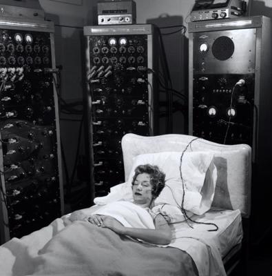 Psihologu un fiziologu uzraudzībā tiek fiksēta cilvēka smadzeņu aktivitāte, asinsspiediens un sirdsdarbība miega laikā. ASV, ap 1955. gadu.