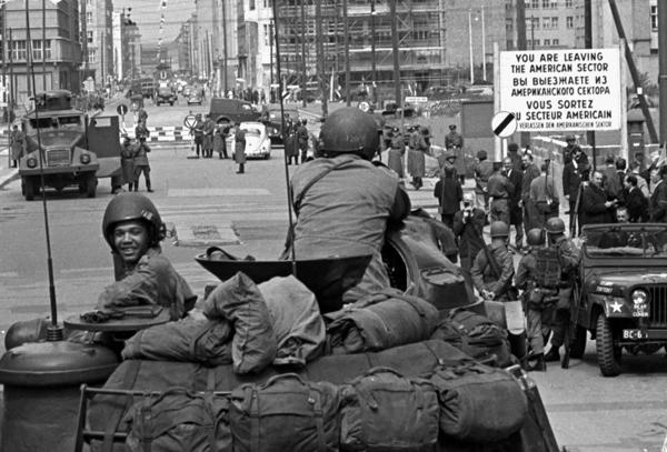 Amerikāņu tanka ekipāža pie Frīdriha ielas pārejas punkta pilsētas centrā no Rietumvalstu kontrolētās Rietumberlīnes uz komunistisko Austrumberlīni. Pretējā pusē redzami pretējās puses robežu apsardzi nodrošinošie karavīri ar ūdensmetēju. Berlīne, 25.08. 1961.