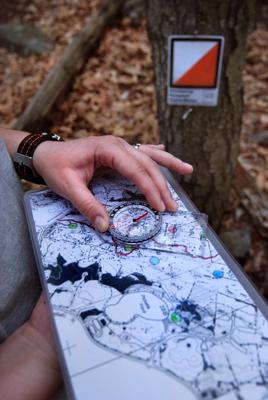 Orientēšanās sacensību dalībnieks ar karti un kompasu. Češīra, ASV, 10.2018.