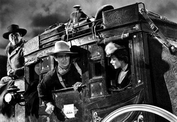 No kreisās: aktieri Džordžs Benkrofts (George Bancroft), Džons Veins (John Wayne) un Luīze Plata (Louise Platt) filmā "Pasta kariete". 1939. gads.