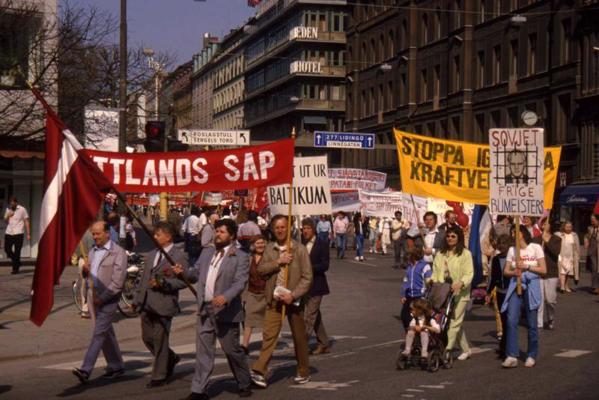 LSDSP dalībnieki Zviedrijas Sociāldemokrātu partijas 1. maija gājienā Stokholmā, Vilnis Zaļkalns nes Latvijas karogu. 20. gs. 80. gadu vidus.