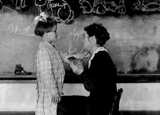 Skolotāja māca skolnieci runāt. Nedzirdīgo apmācības skola, Oklahoma, ASV, 1917. gads.