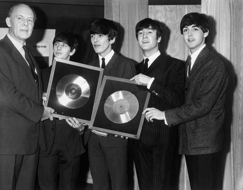 Ierakstu kompānijas EMI priekšsēdētājs Džozefs Lokvuds (Joseph Lockwood) pasniedz grupai The Beatles sudraba diskus par albumiem Please, Please Me un With The Beatles, kuri tobrīd pārdoti vairāk nekā 250 000 eksemplāru tirāžā. 18.11.1963.