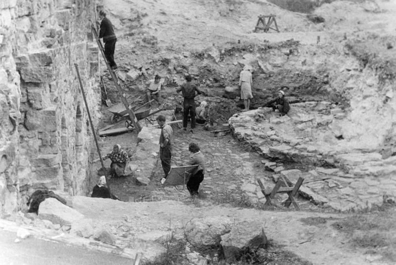 Arheoloģiskie izrakumi Kokneses pilskalnā, bruģa attīrīšana VIII izrakumu laukuma IV slānī. 1964. gads.