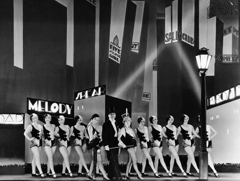 Kadrs no filmas "Brodveja melodija", centrā: Čārlzs Kings (Charles King) un Anita Peidža (Anita Page).1929. gads.