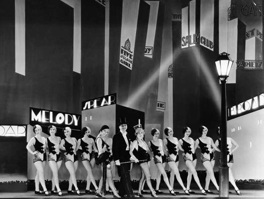 Kadrs no filmas "Brodveja melodija", centrā: Čārlzs Kings (Charles King) un Anita Peidža (Anita Page).1929. gads.