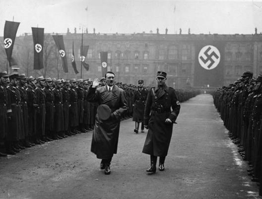 Ādolfs Hitlers pieņem parādi, fonā karogi ar svastiku. Berlīne, 01.1936.