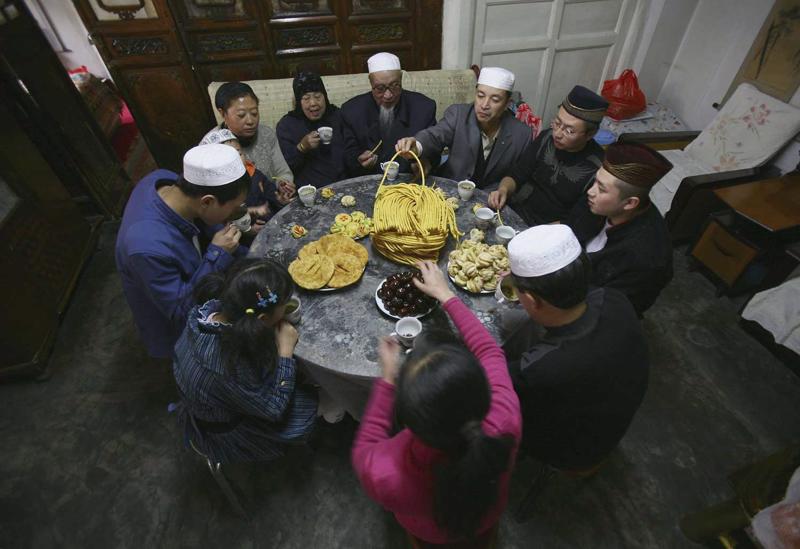 Musulmaņu ģimene ar ‘Īd Āl-Fiṭr svētkiem savās mājās piemin gavēņa beigas. Sjiņiņa, Ķīna, 2006. gads.