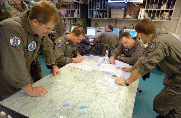 ASV aviācijas bāzes kuģa gaisa kuģu grupas komandiera vietnieks aplūko karti kopā ar Jūras, gaisa un sauszemes (SEAL) astotās komandas locekli un diviem pilotiem misijas plānošanas telpā uz kuģa “USS Harry S. Truman” Vidusjūrā. 19.03.2003.