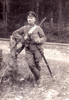 Kurzemes atsevišķā eskadrona seržants K. Rebiņš apbruņots ar 1908. gada parauga karabīni Kar.98 un 1881. gada parauga krievu dragūnu zobenu – šašku. Kurzeme, 12.11.1919.