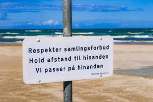 Zīme dāņu valodā, kas aicina ievērot sociālo distancēšanos. Dānija, 07.08.2020.
