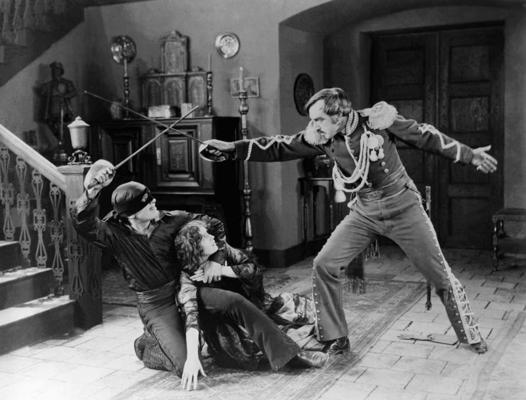 Daglass Fērbenkss, Margerita De La Mote (Marguerite De La Motte) un Roberts Makims (Robert McKim) romantiskā vesterna “Zorro zīme” uzņemšanas laikā. 1920. gads.