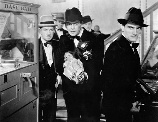 No kreisās: aktieri Vinss Bārnets (Vince Barnett), Pols Muni (Paul Muni) un Džordžs Rafts (George Raft) filmā "Seja ar rētu", 1932. gads.