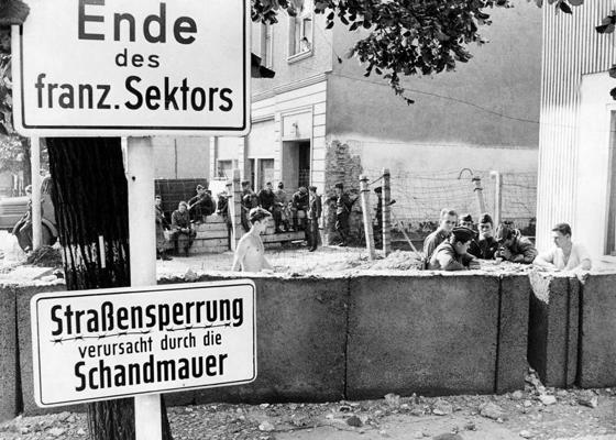 Austrumvācijas policisti pārvieto sienu Bernauer ielā, priekšplānā zīmes ar uzrakstu vācu valodā “kauna mūris” (Die Schandmauer). 1973. gads.