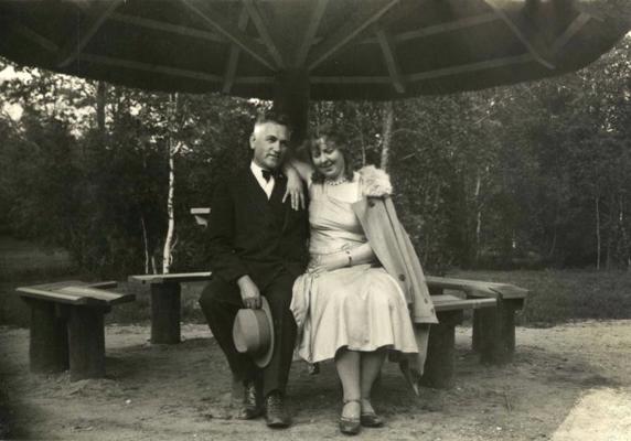 Hilda Vīka ar Viktoru Eglīti sēž zem meldru nojumes ceļmalā. Ap 1930. gadu.