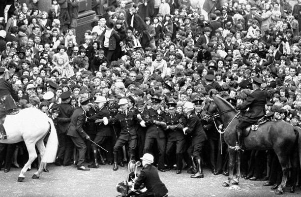 Policija cenšas bloķēt The Beatles fanus pirms grupas ierašanās uz filmas "Grūtas dienas vakars" (A Hard Day's Night) pirmizrādi Liverpūlē. 10.07.1964.