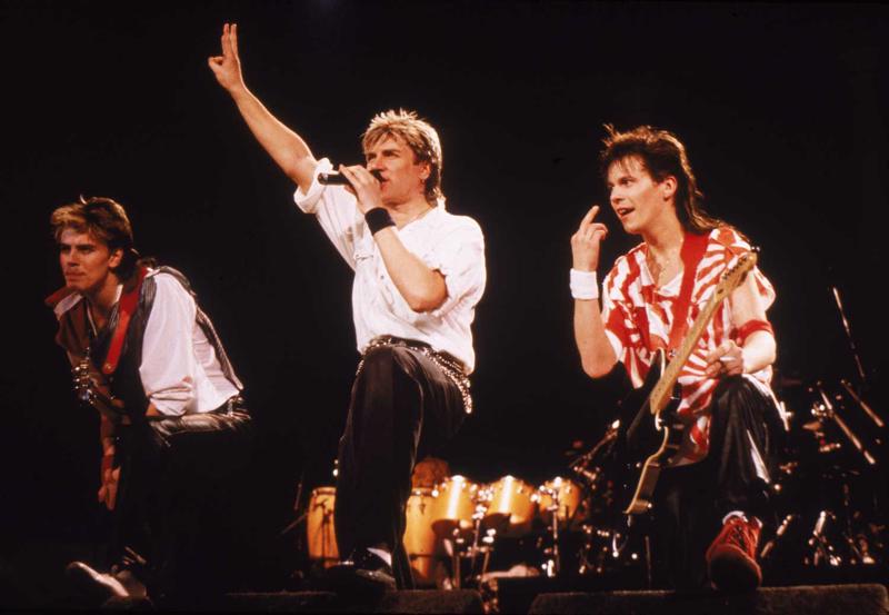 Duran Duran uzstāšanās. No kreisās: Džons Teilors, Saimons Lebons un Endijs Teilors. 1984. gads.