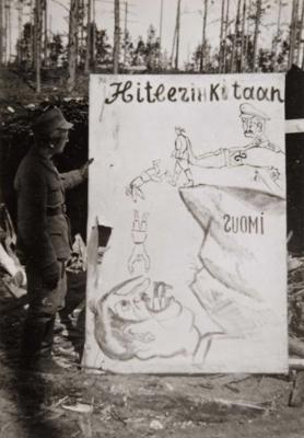 Somu karavīrs pie padomju propagandas plakāta. 1941.–1944. gads.