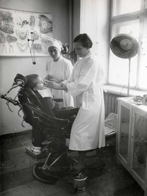 Bērna apskate zobārsta kabinetā Veselības kopšanas parauga punktā Latvijas Sarkanā Krusta Žēlsirdīgo māsu skolā. Rīga, 1937.–1939. gads.