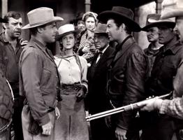 Roberts Teilors (centrā ar tumšo platmali), viņam pretī Braiens Donlevijs (Brian Donlevy) un blakus Mērija Hauarda (Mary Howard) vesternā “Mazulis Billijs”. 1941. gads.