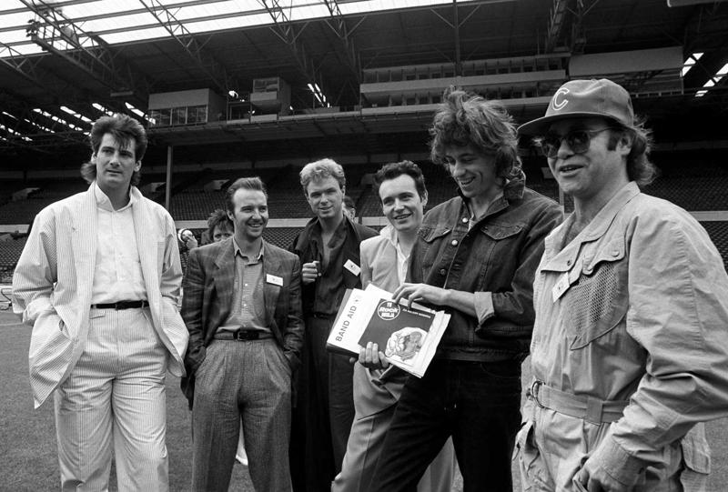 Live Aid koncertakcijas atklāšana. No kreisās: Tonijs Hedlijs (Tony Hadley), Midžs Jūrs, Gērijs Kemps (Gary Kemp), Ādams Ants, Bobs Geldofs un Eltons Džons. Vemblija stadions, Londona, 10.06.1985.
