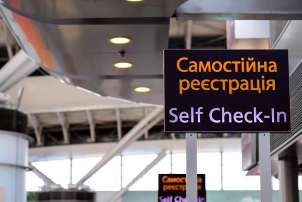 Informācijas stends ar uzrakstu ukraiņu un angļu valodā – pašreģistrēšanās lidostā. 2019. gads.
