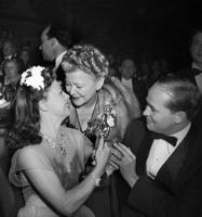 Džindžera Rodžersa rāda savai mātei Līlai Rodžersai balvu "Oskars" par lomu drāmā "Kitija Foila", blakus Džindžerai filmas producents Deivids Hempsteds (David Hempstead). ASV, 1941. gads.