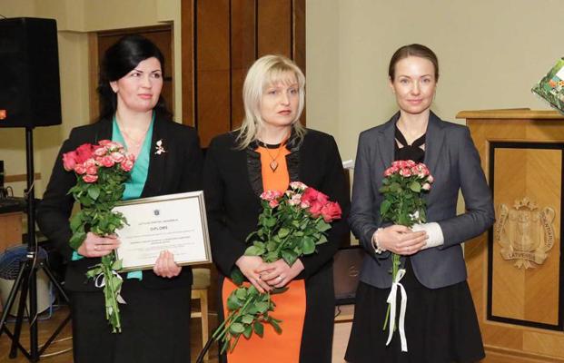 Ilga Gedrovica (pirmā no kreisās) un Sandra Muižniece-Brasava (otrā no kreisās), saņemot apbalvojumu par 2015. g. sasniegumiem zinātnē. Latvijas Zinātņu akadēmija, 19.01.2016.