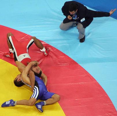Šerefs Eroglu (Şeref Eroğlu, zilā tērpā) no Turcijas un Farids Mansurovs (Fərid Mansurov, sarkanā tērpā) no Azerbaidžānas cīnās par olimpisko zelta medaļu grieķu-romiešu cīņā 66 kg svara kategorijā. Atēnas, 25.08.2004.