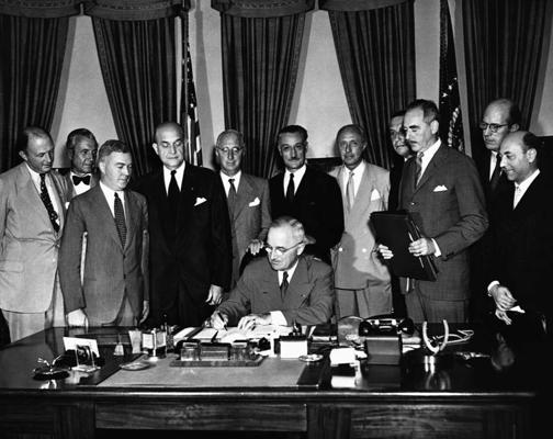 ASV prezidents Harijs Trūmens (Harry Truman) paraksta Ziemeļatlantijas paktu, izveidojot Ziemeļatlantijas līguma organizāciju (NATO), ap viņu ārvalstu diplomāti. 24.08.1949.