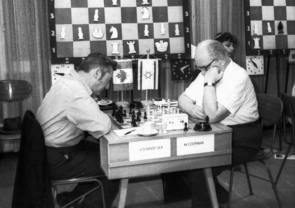 Izraēlas starptautiskais šaha meistars Moše Čerņaks (משה צ'רניאק‎) spēlē šahu ar Kanādas starptautisko šaha lielmeistaru Danielu Janofski (Daniel Abraham Yanofsky). Izraēla, 1969. gads.