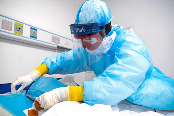Medicīnas darbinieks veic hemodialīzes procedūru urēmiskajam pacientam, kurš atveseļojas pēc Covid-19 infekcijas slimības Hankou slimnīcā Uhaņā. Ķīna, 21.03.2020.