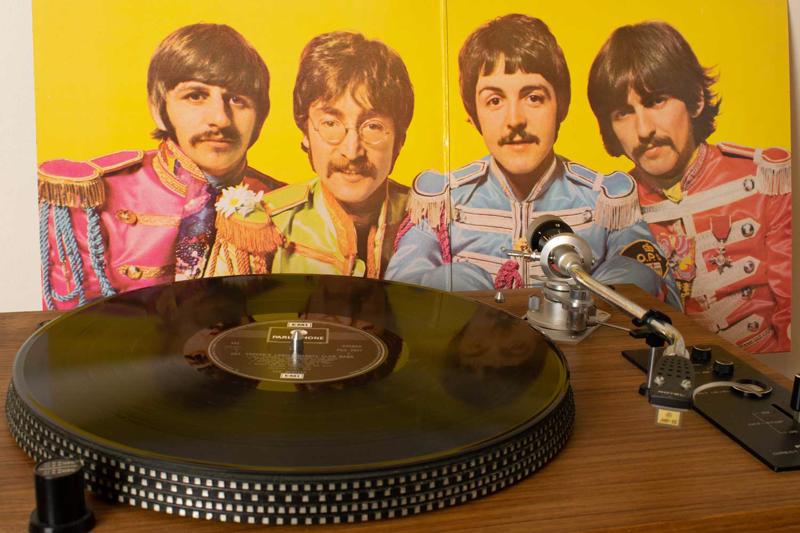 Uz plašu atskaņotāja The Beatles konceptalbums Sgt. Pepper’s Lonely Hearts Club Band (1967), fonā albuma vāka atvērums. Mančestra, Lielbritānija, 06.01.2020.
