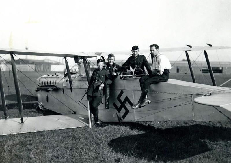 Latvijas armijas Aviācijas pulka lidotāji pie Latvijas armijas lidmašīnas ar pazīšanas zīmi ugunskrustu. 20. gs. 20. gadi.