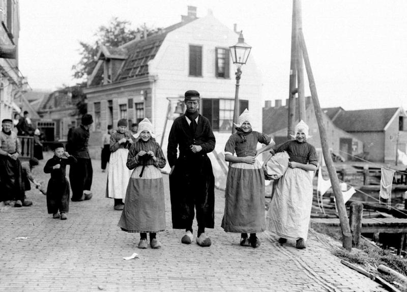 Zvejnieki tradicionālajos tērpos Volendamas ostas pilsētā. Nīderlande, 1910. gads.